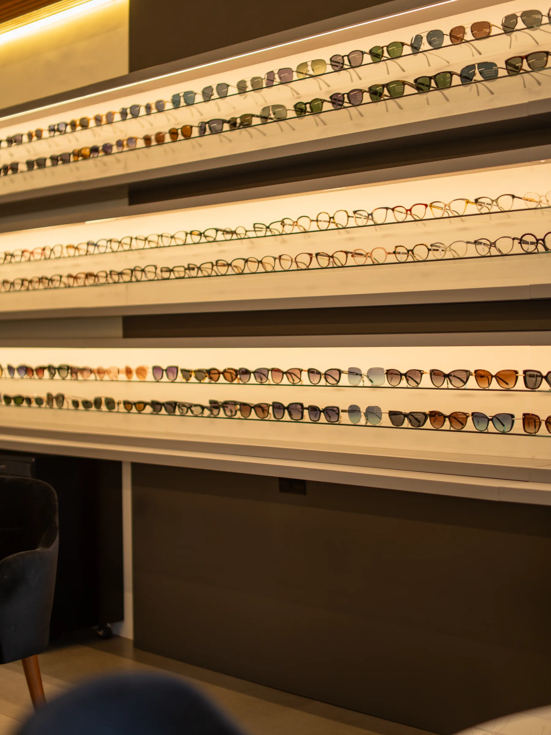 Parede iluminada da Visolux com curadoria de óculos em exposição