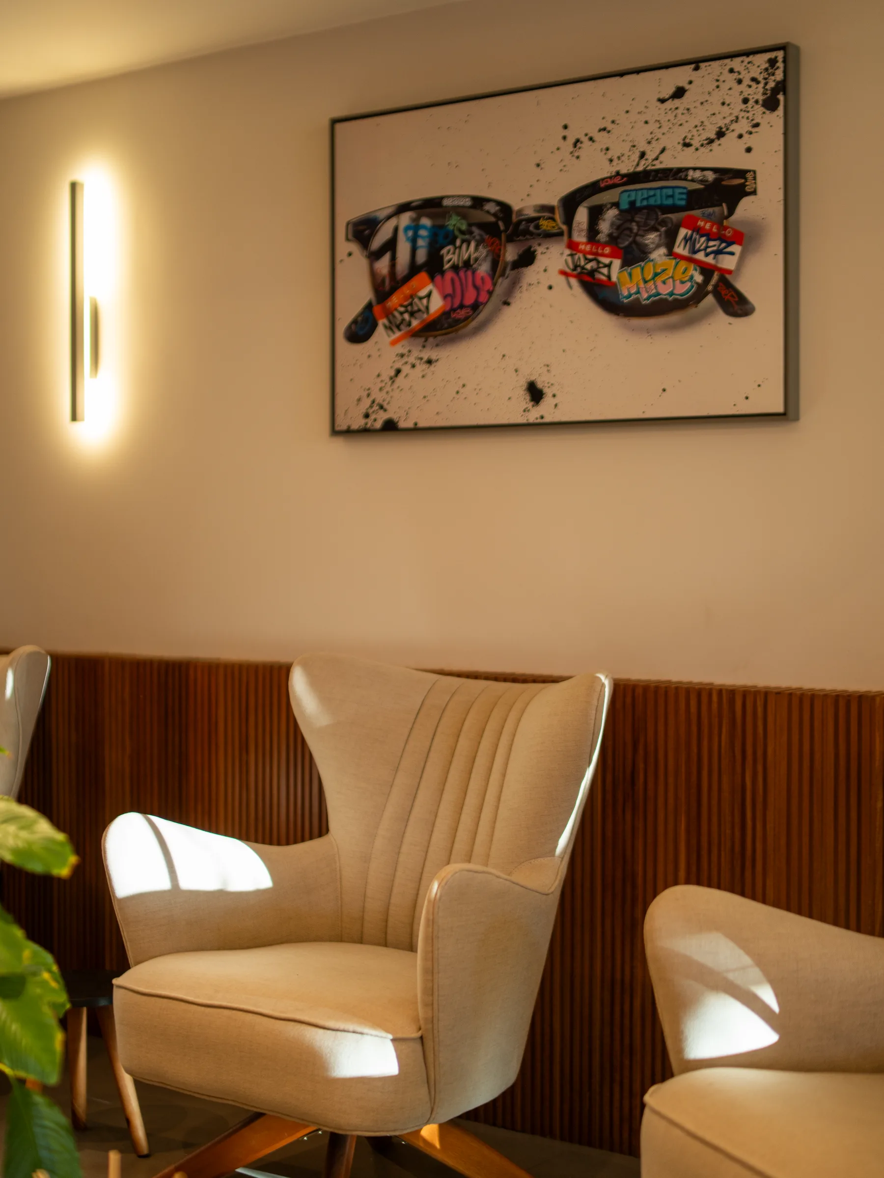 Ambiente acolhedor da Visolux com poltrona e painel de madeira